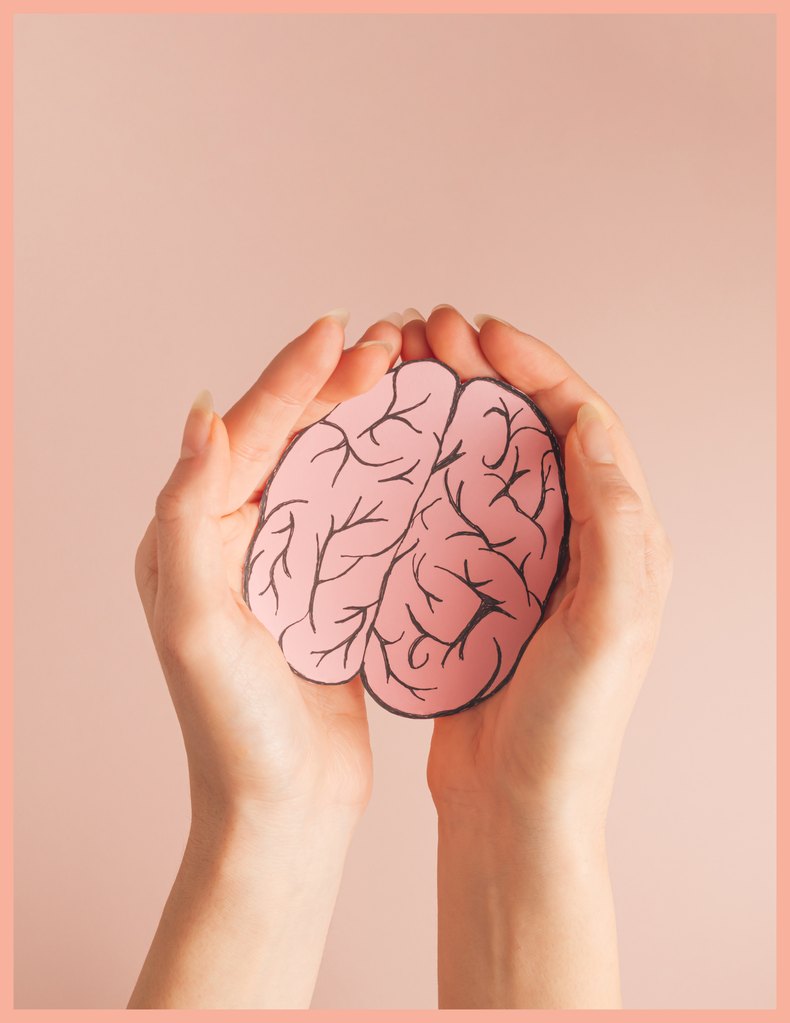 Manos sosteniendo un cerebro de papel